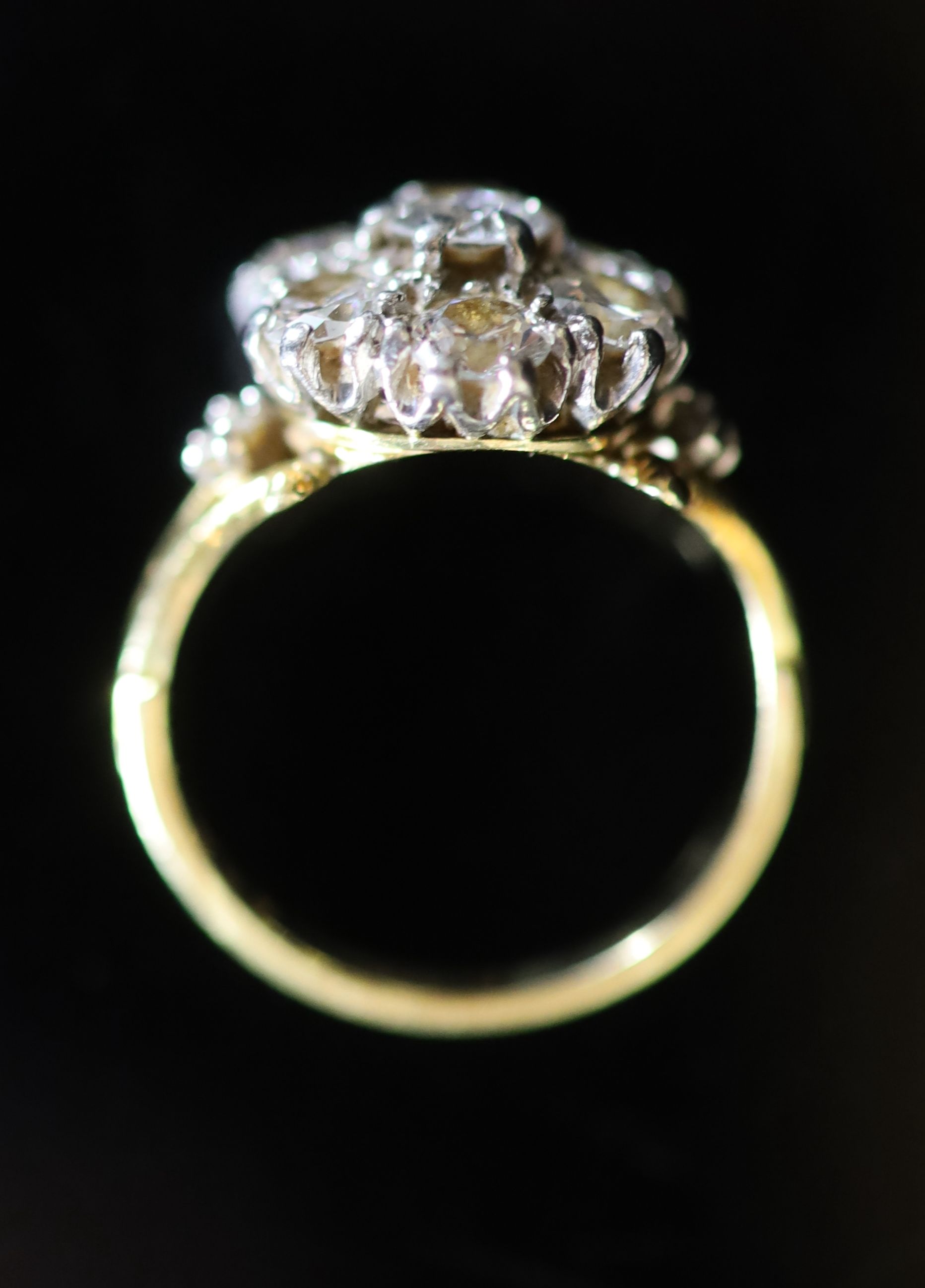 A mid 20th century gold and seven stone diamond cluster ring